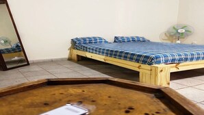 A room with a bed, a mirror, a fan, and a wooden table. - Serene Room and Living Room (Serrekunda)