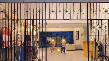 A gated entrance to a modern interior space with a large window and a seating area.