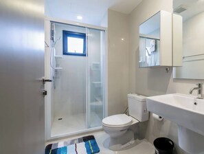 A modern bathroom with a glass-enclosed shower, a white toilet, a sink with a mirror above it, and a red towel hanging on the wall. - Exclusive Sea View 2 Bed Room High Floor 2 Balcony (Muang Pattaya)