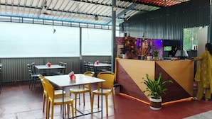 Un restaurant avec des tables et des chaises, un comptoir au décor soigné et une grande fenêtre.