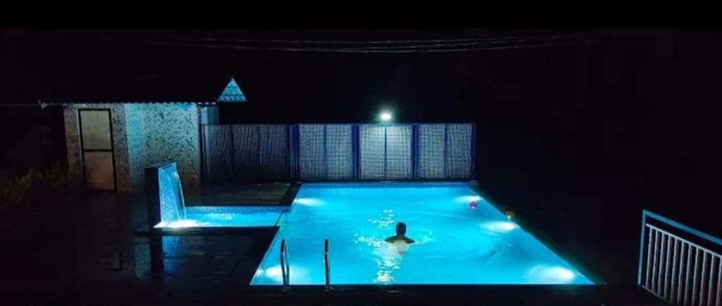 A swimming pool at night with lights.