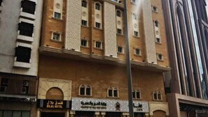 A multi-story hotel with a central courtyard, featuring a mix of brick and glass facades, and a visible entrance with signage. - Bilal hotel  (Makkah)