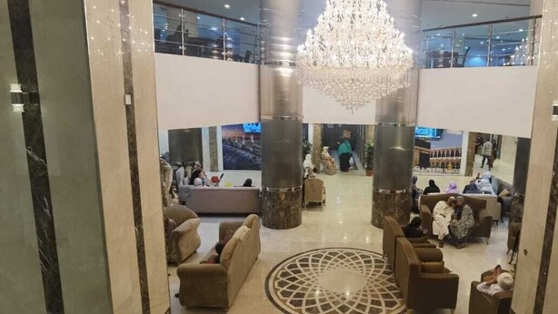 A spacious lobby with a central chandelier, seating areas, and a view of the upper floor. - Bilal hotel  (Makkah)