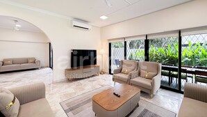 Un salón amplio con un conjunto de sofás, una mesa de centro y un televisor.