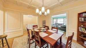 A dining area with a wooden table and chairs, a chandelier, and a bookshelf. - 4BR【Walk Score 80】Wrap-Around Deck-Next to GG Park (San Francisco)