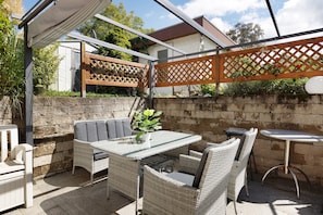 An outdoor patio with wicker furniture, a table, and a chair.