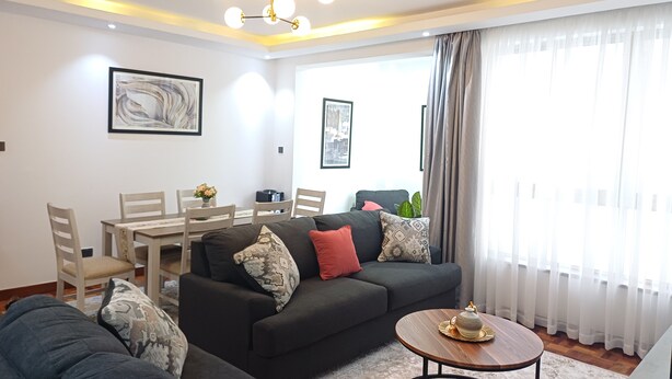Una sala moderna con un sofá, una mesa de comedor y una mesa de centro.