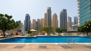 A swimming pool with a city skyline in the background. - Unique spacious 1 BR Porsche Design Marina View (Dubai)