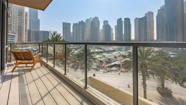 Un balcon donnant sur une marina et des immeubles de grande hauteur.