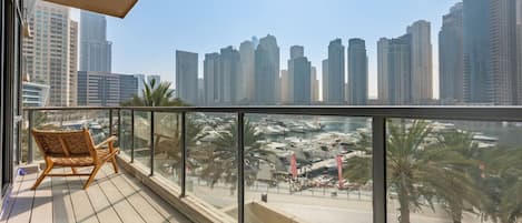 Un balcon donnant sur une marina et des immeubles de grande hauteur.