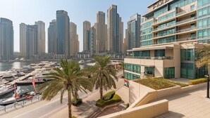 A modern hotel with a view of a marina and high-rise buildings. - Unique spacious 1 BR Porsche Design Marina View (Dubai)