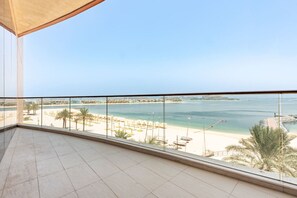 Un balcon offrant une vue dégagée sur une plage et la mer.