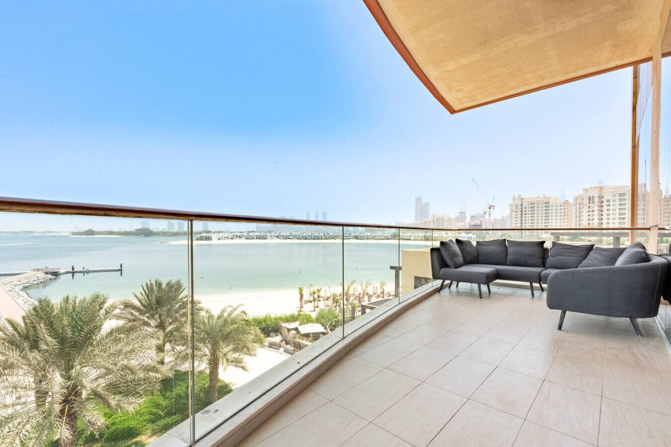 Un balcon avec vue sur une plage et sur les bâtiments de la ville.