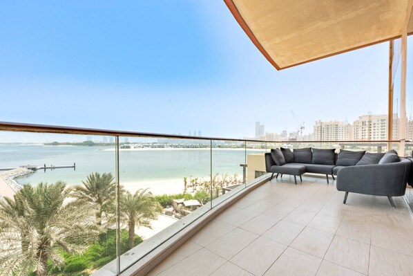A balcony with a view of a beach and city skyline.