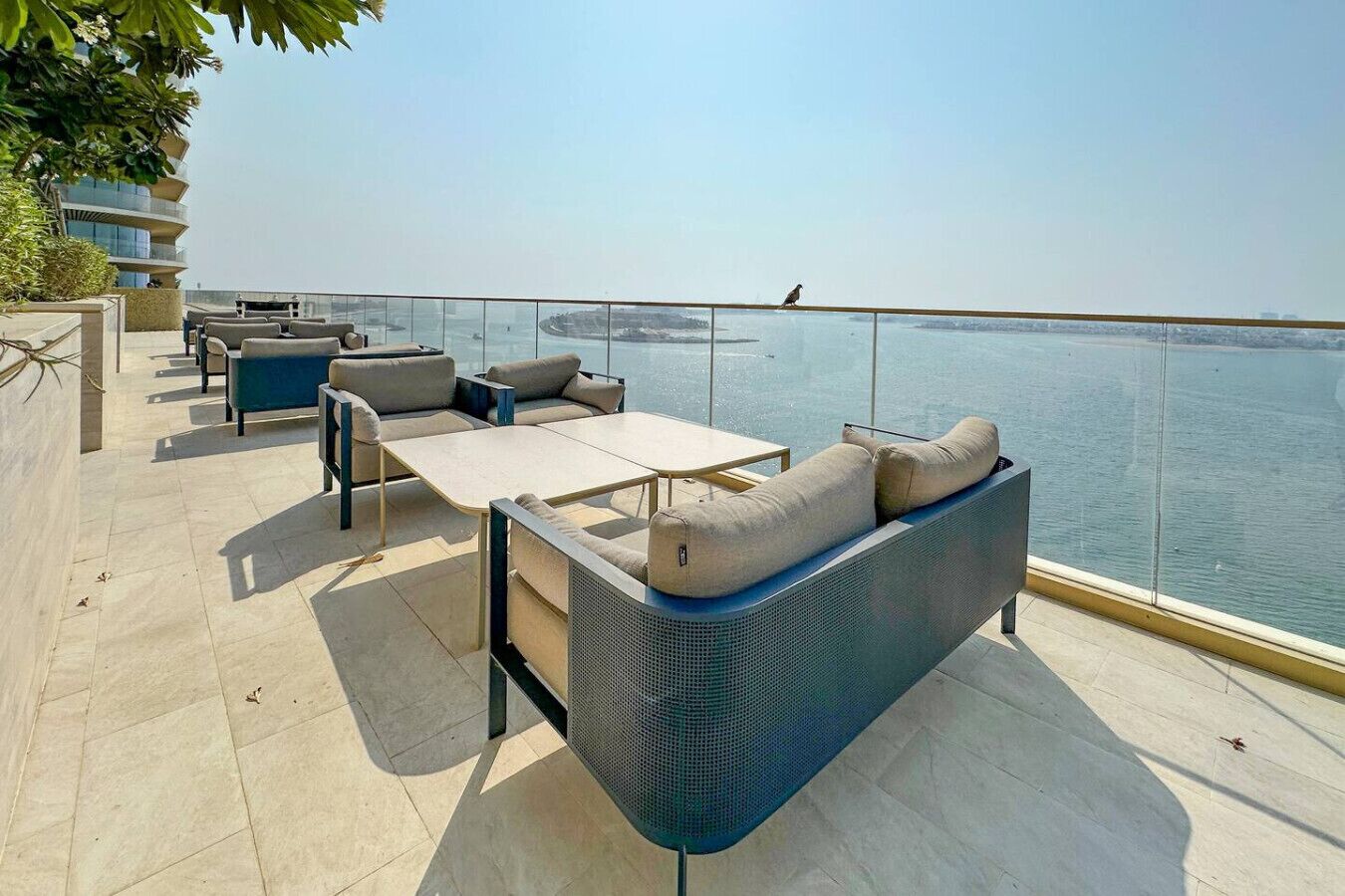 A rooftop terrace with outdoor seating and a view of the sea.