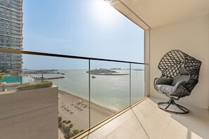 Un balcon avec vue sur une étendue d’eau, une piscine et une chaise.