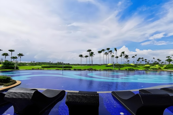 Una piscina al aire libre, sillones reclinables de piscina