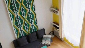 A compact living space with a sofa, a small round table, and a patterned wall. - Cosy, Old Lille, Unique, Neo-Vintage (Lille)