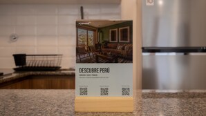 A brochure stand in a kitchen with a view of a living room. - w* | Chic 1BR Apartment in Miraflores (Lima)