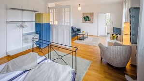 Ein modernes Schlafzimmer mit einem Bett, einem kleinen Schreibtisch, einem Stuhl und einem Kleiderschrank.