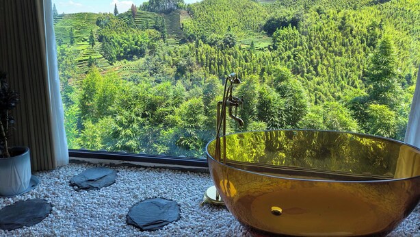 A room with a large window overlooking a lush green landscape. - Shanye Lianglu (Leshan)