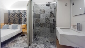 Een moderne badkamer met een douche, wastafel en spiegel.