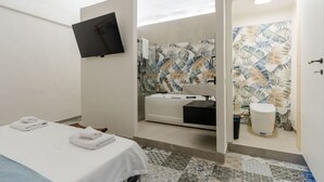 Een moderne badkamer met douche, toilet en wastafel.