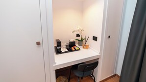 A small, well-lit room with a white desk, a chair, a potted plant, and a tray with various items. - Casa Palmeri (Rome)