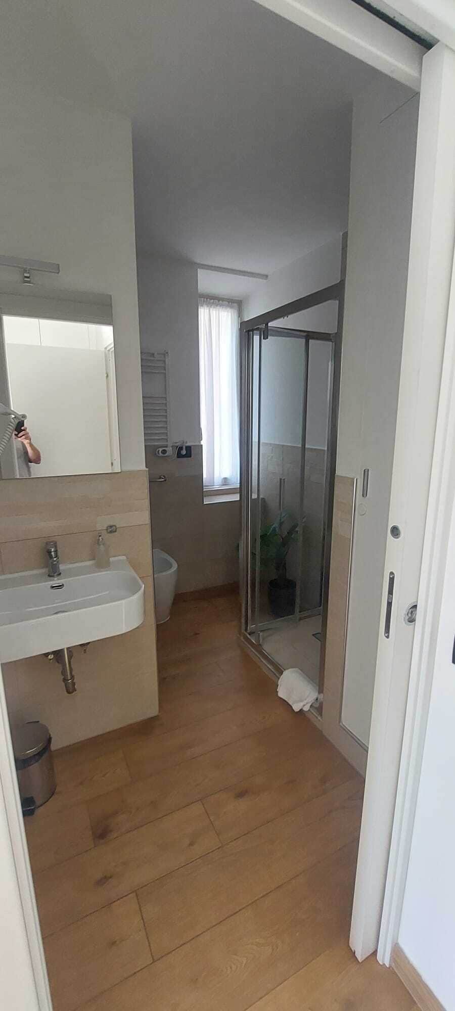 Une salle de bain avec douche, toilettes et lavabo.