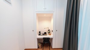 A small office space with a desk, chair, and a trash bin.
