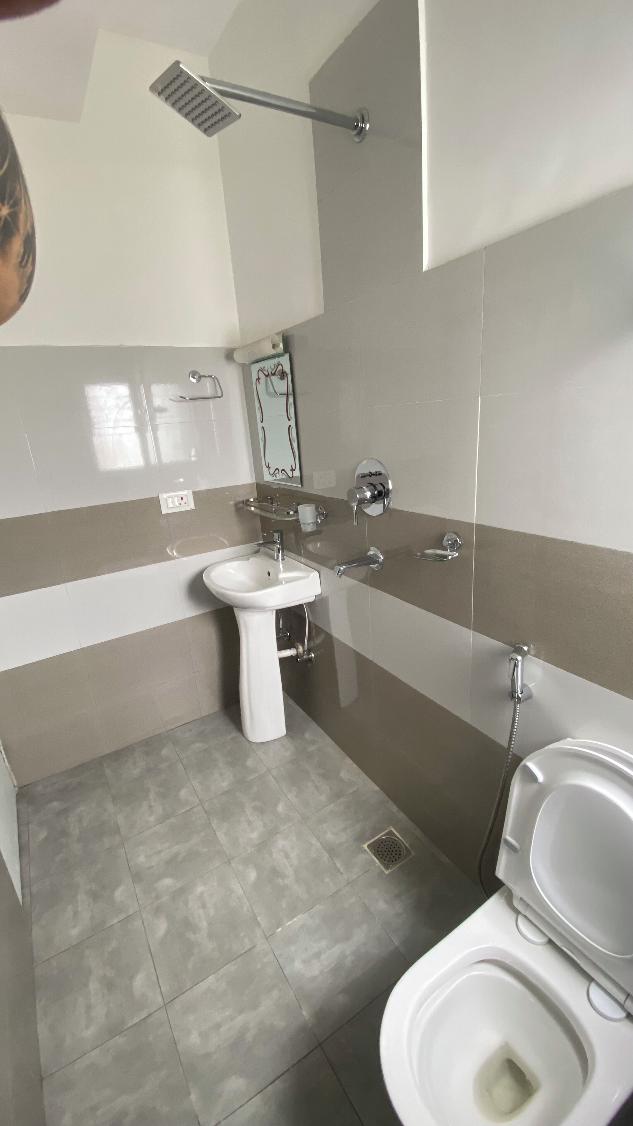 Une salle de bain avec des toilettes, un lavabo et une douche.