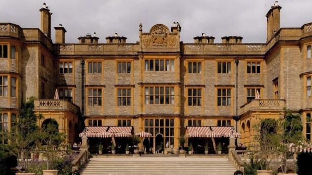 A large, historic building with a central courtyard and a pool.