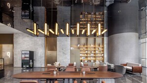 A modern conference room with a large table, comfortable seating, and a unique ceiling light fixture.