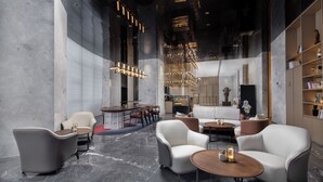 A modern interior with seating areas, a bar, and a reception desk.