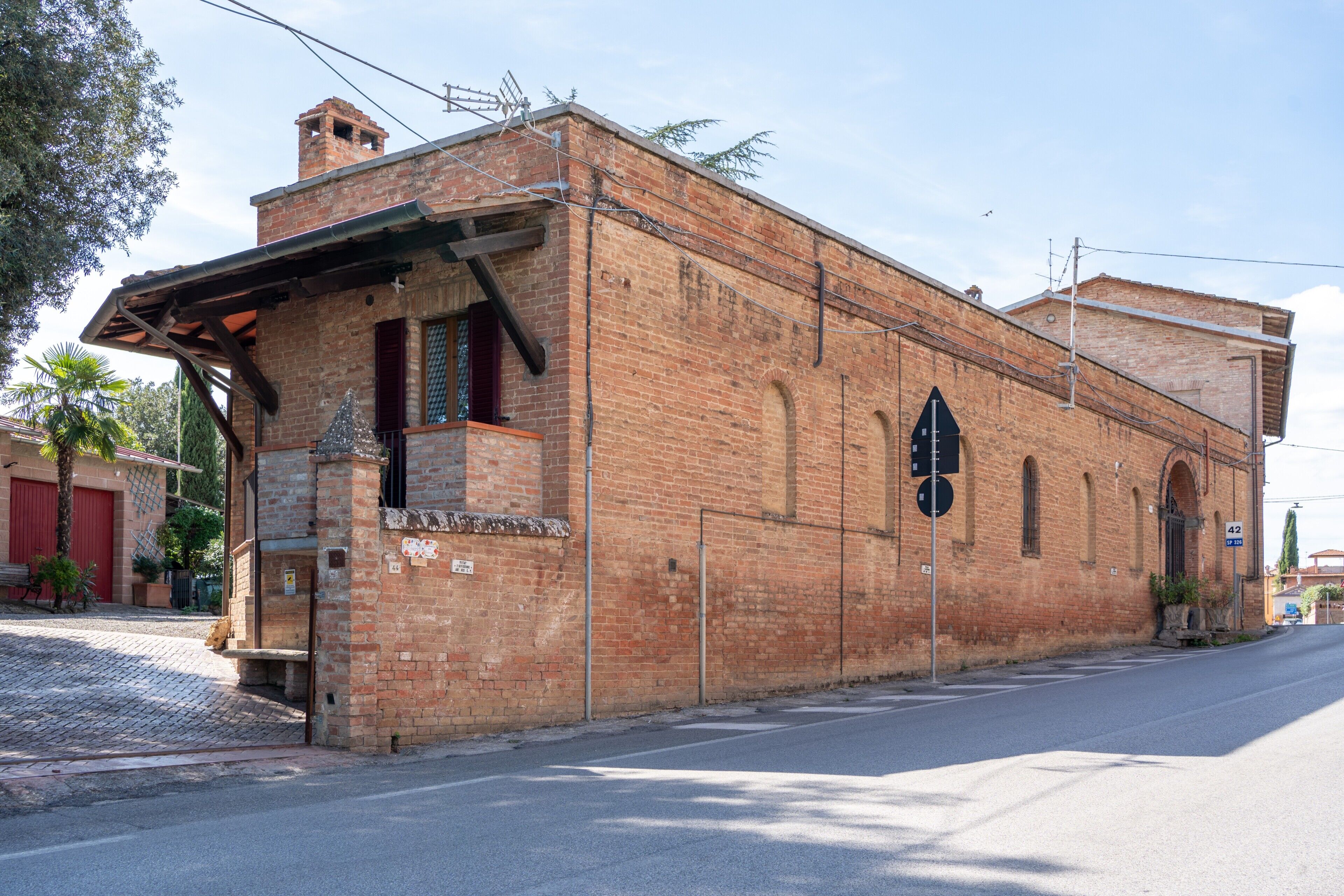 A brick building with a flat roof, a small porch, and a single visible window.