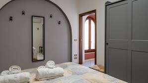 Une chambre à coucher avec un lit, des serviettes, un miroir et une armoire.