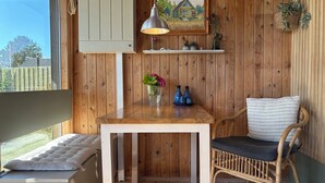 A wooden interior with a table, chair, and a painting on the wall. - Cozy small holiday home with sea view (Sydals)