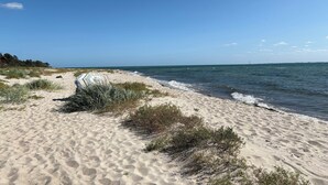 A sandy beach with sparse vegetation and a clear blue sky. - Cozy small holiday home with sea view (Sydals)