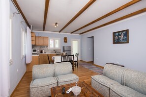 A living room with two sofas, a coffee table, and a kitchen in the background.