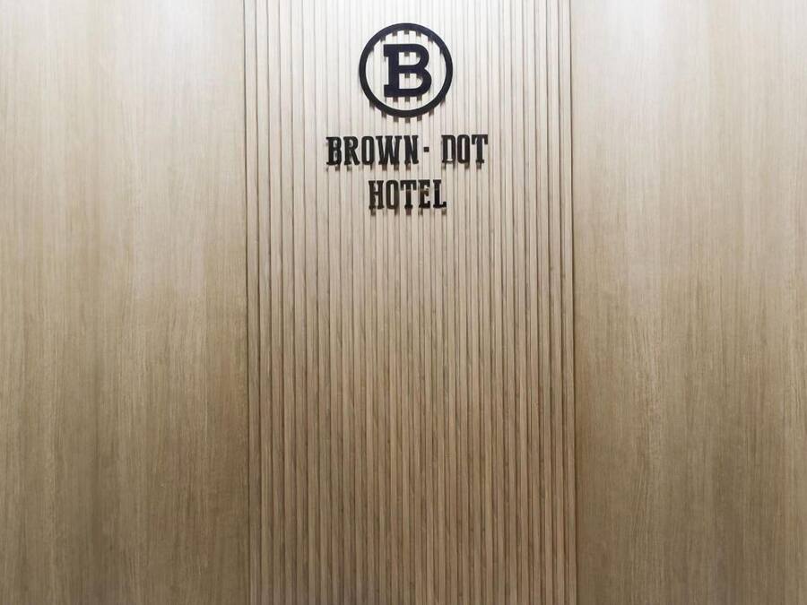 A vertical wooden panel with a logo and text indicating 'BROWN DOT HOTEL'.