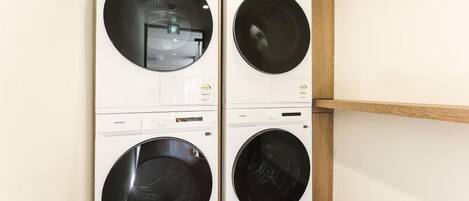 A laundry room with four front-loading washing machines.