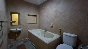 A bathroom with a bathtub, a toilet, a sink, and a mirror.