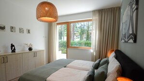 Ein Schlafzimmer mit einem Bett, einem Schminktisch, einem Fenster mit Vorhängen und Bildern an der Wand.