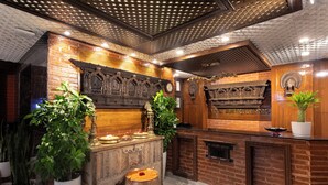 A traditional interior with a brick wall, wooden counter, and decorative elements. - Royal Boutique Hotel (Kathmandu)