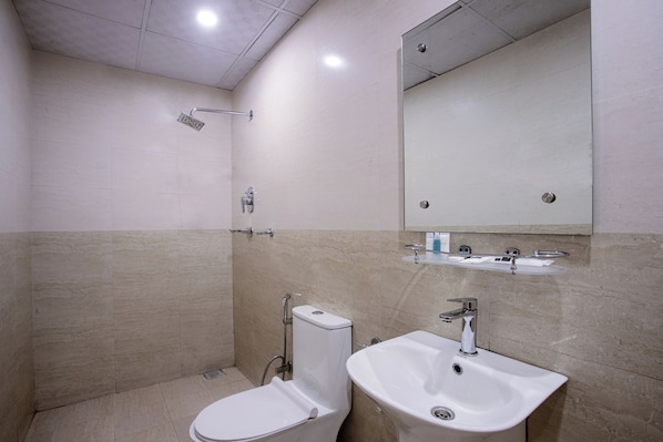 Un baño moderno con ducha, inodoro y lavamanos.