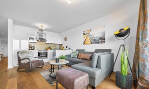 A modern living room with a grey sofa, a brown leather chair, a small coffee table, and a large floor lamp.