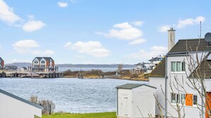 A waterfront property with a dock, a bridge, and a view of the water.