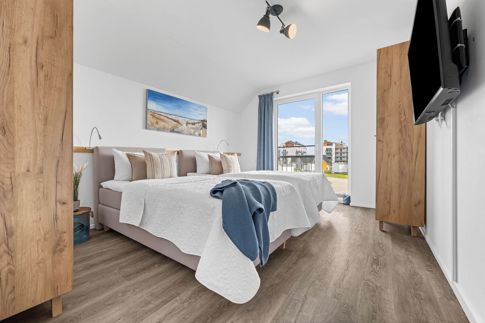 Une chambre à coucher avec un lit, un tableau, une fenêtre et un téléviseur.