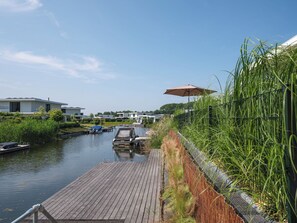 Property grounds - Modern 8-person waterfront villa with fenced garden, private jetty, spacious open living area and full comfort for families – pets welcome. (Zeewolde)
