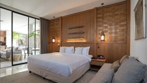 A modern bedroom with a large bed, a wooden accent wall, and a view through glass doors to an outdoor area. - Deo Villa Seminyak (Seminyak)